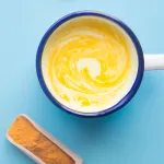 turmeric coconut coffee in the vintage glass with blue background