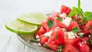 watermelon salad with cheese with lime on the side on the glass plate