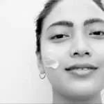 smiling lady using face skin care by awild