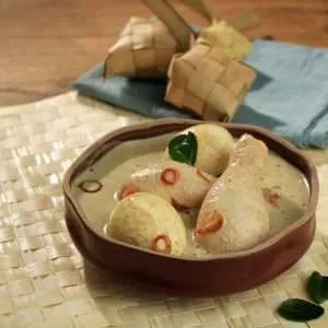 opor ayam in wood bowl and ketupat vintage style photo