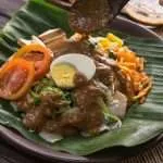 Gado-Gado Indonesian Salad on wood plate and banana leaves